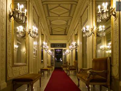 L�ambiente, illuminato da candelabri a parete, � scandito da panche e divanetti in tessuto...
